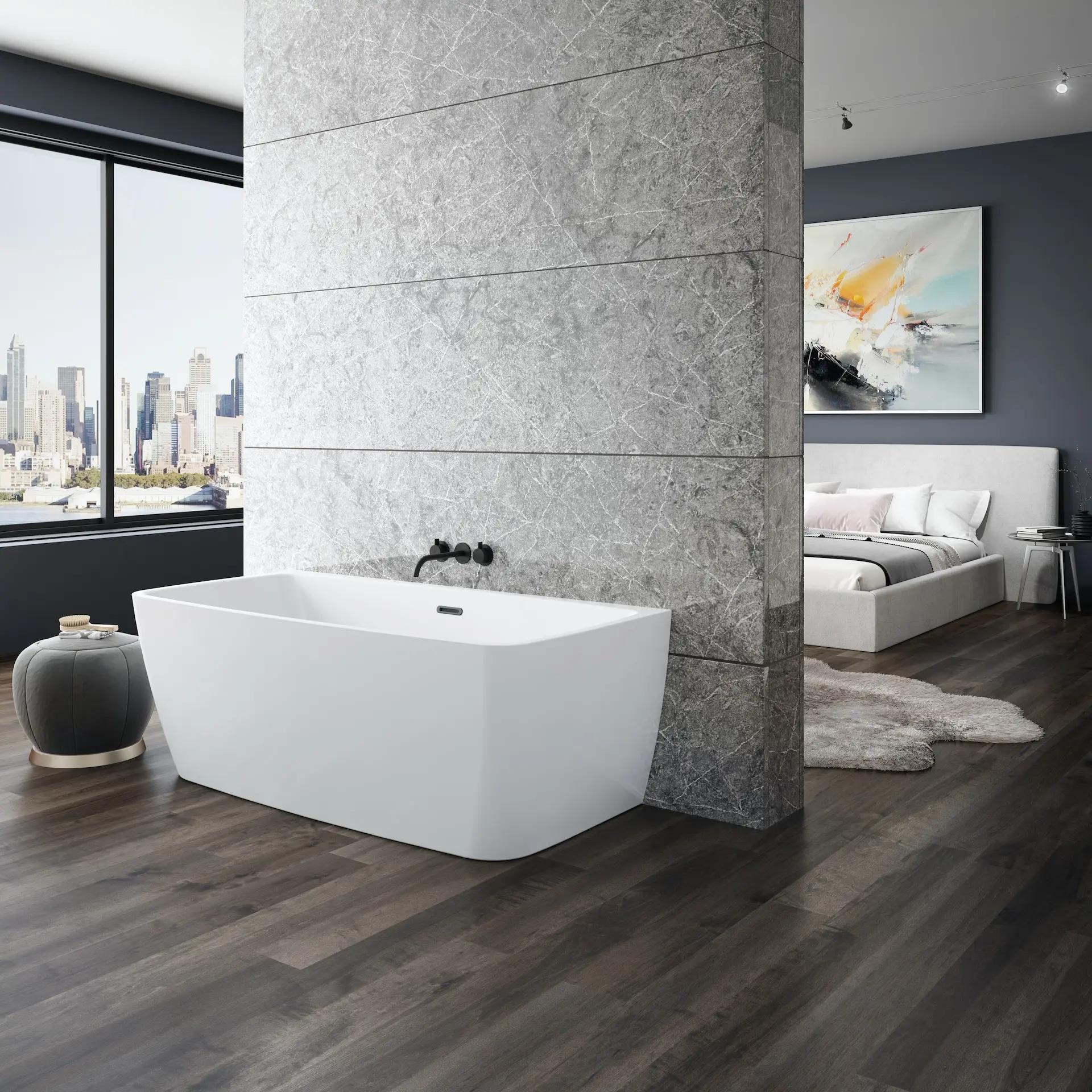Modern freestanding white bathtub against a stone accent wall, with a bedroom and city skyline windows visible beyond.