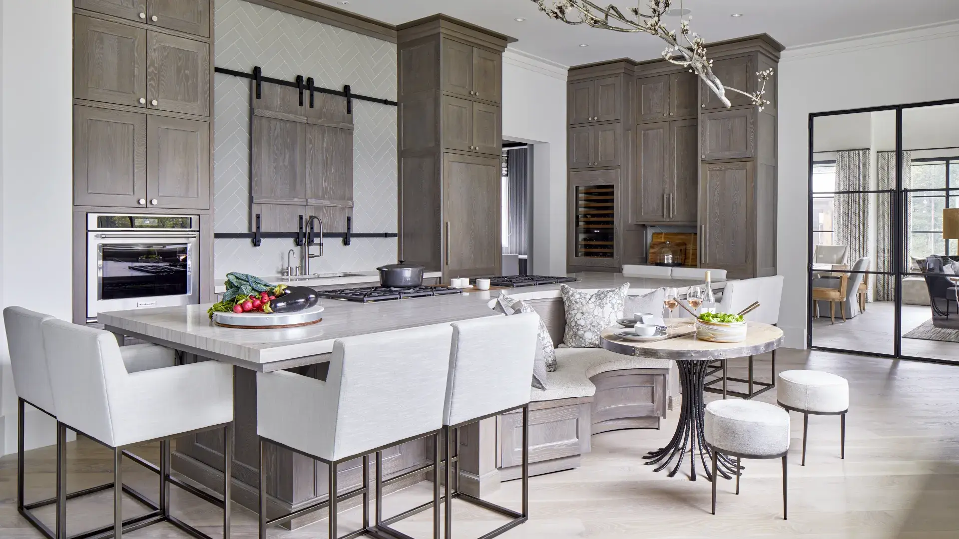 Modern kitchen featuring an island, white cabinetry, stylish lighting, and elegant decor elements.
