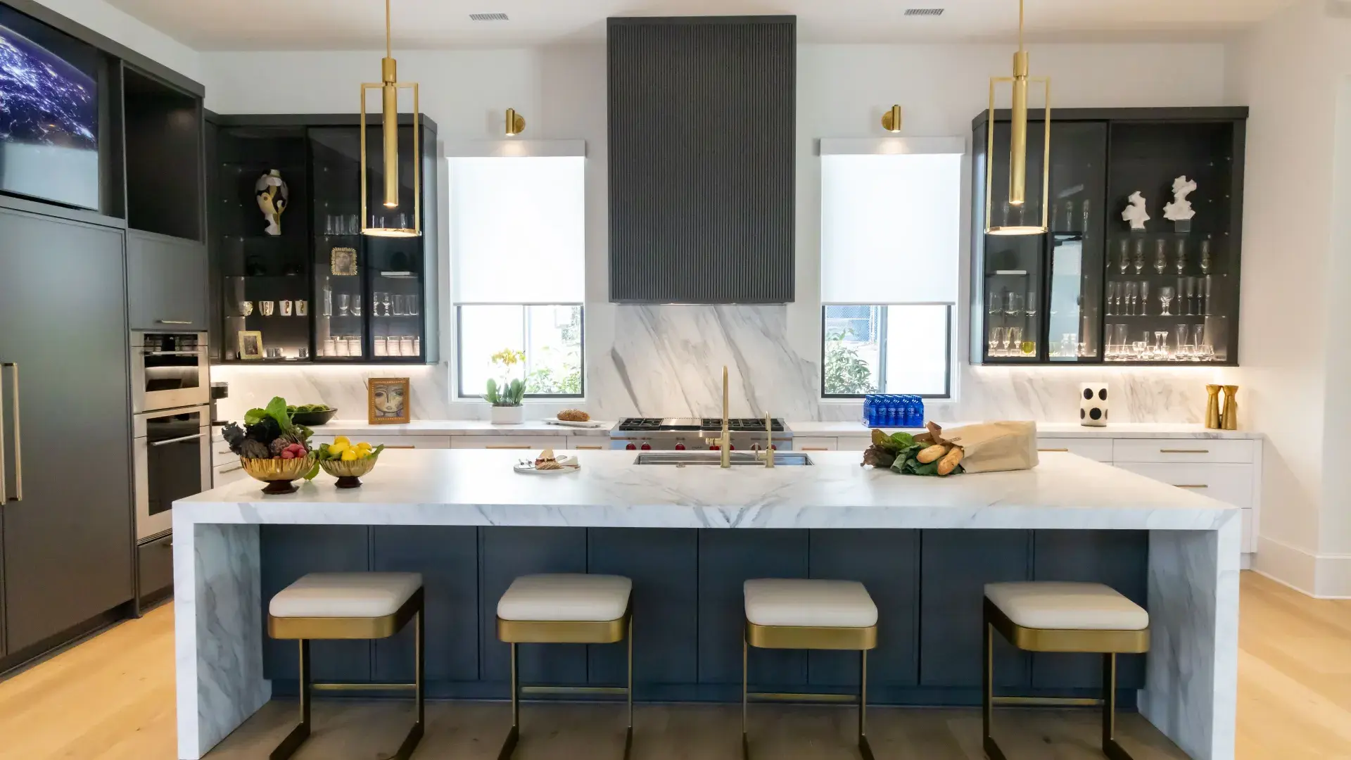 Modern kitchen featuring an island, white cabinetry, stylish lighting, and elegant decor elements.