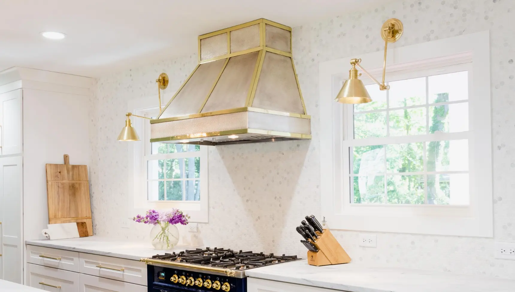 Modern kitchen featuring a blue stove, white cabinetry, and stylish gold accents.
