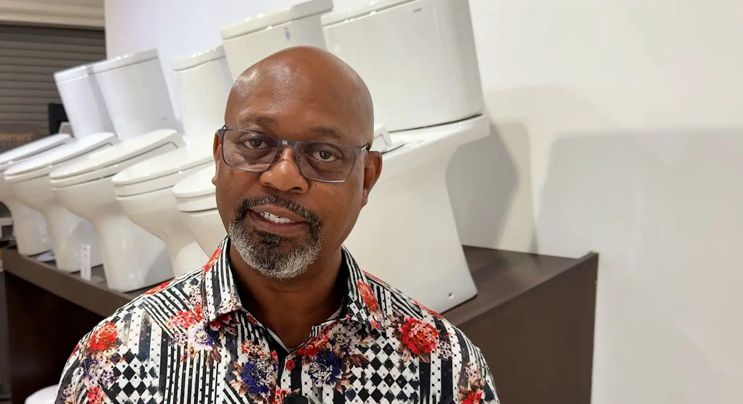 Showroom associate standing in front of a row of white TOTO toilets