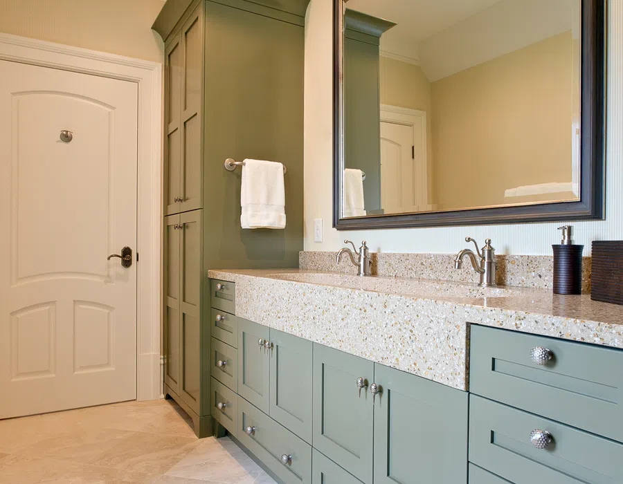 Modern bathroom with large green cabinetry, dual sinks, granite countertop, and a large wall mirror.