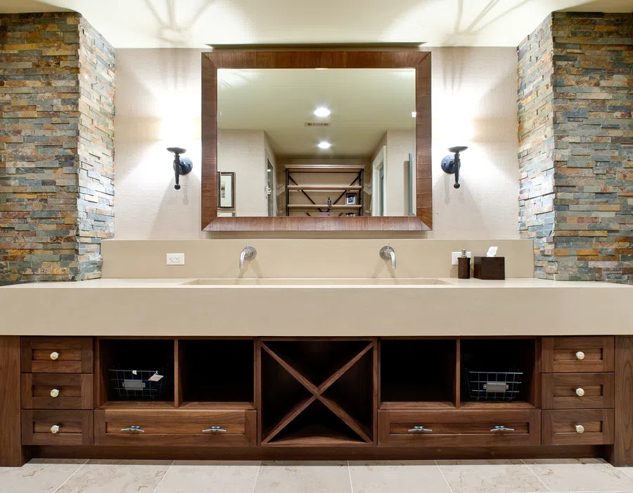 Modern double-sink bathroom vanity with beige countertop, wooden drawers, and stone pillar accents.